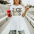 Neutral Marquee Mascot A-P DTF Transfers | School Spirit Mascot Collection, person holding a Coca-Cola cup and showing a peace sign in an outdoor stadium.