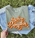 Hey There Pumpkin DTF Transfer, retro fall script design on a green sweatshirt, with blue denim jeans in the background.