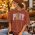 PRAY patchwork-style DTF transfer with floral, leopard, pumpkin, and polka dot pattern letters in pink, green, and blue tones