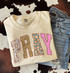 PRAY Patchwork DTF Transfer | Fall Faith Design with Floral & Pumpkin Print Letters, a beige sweatshirt with colorful patchwork-style 'PRAY' lettering and a pair of distressed blue jeans, on a patterned textile background.
