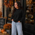 Blank Mockneck Sweatshirt — Preorder | Multiple Colors, black mockneck sweatshirt worn by a woman with autumn decorations outside a boutique store.