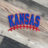 Kansas Football Chenille Patch | Red Blue Spirit Patch, an embroidered patch with the word 'Kansas' in bold blue letters outlined in red, featuring a red football stitching detail underneath on a wooden surface.