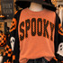 Orange polka dot SPOOKY corduroy appliqué patch with black embroidered edging shown on yam comfort colors