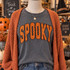 Orange and black polka dot SPOOKY corduroy appliqué patch with embroidered edging shown on charcoal Halloween shirt