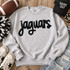 Black Jaguars fluffy heat press appliqué patch with script lettering displayed on a light gray sweatshirt.