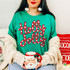 Holly Jolly Christmas DTF transfer with red and white polka-dot distressed script lettering on a green shirt