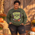 Quilted patchwork Frankenstein's monster face DTF transfer with stitched seams, polka-dot ears, bolt bones, and a plaid bow tie Shown on a Military Green crewneck sweatshirt.