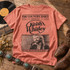 Keith Whitley vintage newspaper-style DTF transfer with The Country Daily masthead, script logo, black-and-white singing photo, and 'Don't Close Your Eyes - When You Say Nothing At All' caption Shown on a Bright Salmon t-shirt.