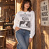 Vintage newspaper-style DTF transfer with REBA masthead, black and white country singer portrait, and 'Fancy - The Night the Lights Went Out in Georgia' headline on a yellow t-shirt Shown on a White crewneck sweatshirt.
