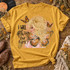 I Will Always Love You DTF transfer with illustrated blonde woman wearing a gold halo and monarch butterfly wings, surrounded by flying butterflies and gold glitter-style splatter Shown on a Mustard t-shirt.