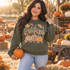Hello Pumpkin DTF transfer with maple and oak leaves, stars, and three stacked pumpkins in gingham, leopard, and polka dot patterns Shown on a Military Green crewneck sweatshirt.