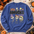 Zero Amucks Given Halloween DTF transfer with three dancing skeleton girls with colorful hair, a skeleton cat, and stars Shown on a Heather Deep Royal crewneck sweatshirt.