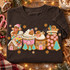 Gingerbread-themed mugs, jars, and cups DTF transfer with whipped cream, gingerbread men, candy, and gold snowflakes in a plush crochet-textured style Shown on a Pepper t-shirt.