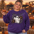Spooky-cute ghost DTF transfer with glitter-style stitching, black lace spiderwebs, bats, stars, and orange daisy flowers in a Halloween patch design Shown on a Purple crewneck sweatshirt.