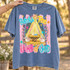 Behold The Lamb of God nativity DTF transfer with baby Jesus in a manger, Star of Bethlehem, lambs, and scalloped pink striped border Shown on a Blue Jean t-shirt.