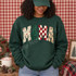 MAMA Christmas DTF transfer with four textured letters featuring holiday floral, glitter green, checker print, and Christmas tree designs Shown on a Forest crewneck sweatshirt.