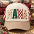 MAMA Christmas DTF transfer with four textured letters featuring holiday floral, glitter green, checker print, and Christmas tree designs Shown on a ivory front panel, tan bill, red-and-cream checkered mesh back trucker hat.