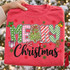 Merry Christmas DTF transfer with mixed-pattern block letters, a hand-drawn Christmas tree, holly, gingerbread man, gift box, candy cane, stocking, jingle bells, and red and green snowflakes on a red shirt Shown on a Watermelon t-shirt.