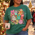 Colorful 'Merry' Christmas DTF transfer with gingerbread man, candy cane, Christmas tree, wreath, and ornament on a confetti background Shown on a Island Green t-shirt.