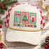 Oh Come Let Us Adore Him Christmas DTF transfer with scalloped striped panels featuring a bow, Christmas tree, and angel above colorful block lettering Shown on a ivory cream front panel, gold rope, red and white checkered mesh back trucker hat.