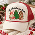 Oh Christmas Tree DTF transfer with three crocheted-look Christmas tree cookie designs in red and white, green, and gingerbread icing styles, surrounded by stars, under black brush-script lettering Shown on a Ivory front panel, brick red mesh back, red rope trucker hat.