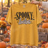 Spooky Babe Halloween DTF transfer with retro block lettering, graffiti-style script, bat silhouettes, sparkles, and checkerboard border on a mustard yellow shirt Shown on a Mustard t-shirt.