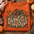 Thankful leopard print pumpkin DTF transfer with embroidered-style bubble lettering, glittery stem, leaf, and leopard spot patches Shown on a Orange crewneck sweatshirt.