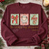 The Lord Is My Shepherd Christmas DTF transfer with scalloped candy-cane striped panels featuring a red bow, fluffy lamb, and ribboned cross above Psalm 23:1 hand-lettered scripture Shown on a Heather Dark Maroon crewneck sweatshirt.