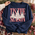 Tis the Season DTF transfer with three lace-textured ivory Christmas trees topped with lace stars over red-and-white gingham lettering Shown on a Navy crewneck sweatshirt.