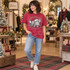 Sleepy gray mouse in a fuzzy white-trimmed Santa hat resting on a red and green plaid pillow DTF transfer with Christmas script text Shown on a Crunchberry t-shirt.