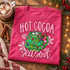 Hot Cocoa Season DTF transfer with a Christmas tree shaped mug filled with cocoa and marshmallows, string lights, ornaments, a red bow, and snowflakes Shown on a Crunchberry t-shirt.