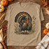 Vintage Wild Turkey DTF Transfer | Watercolor Thanksgiving Fall Design, tan T-shirt featuring a vintage watercolor wild turkey surrounded by autumn foliage, styled with pumpkins and fall decor on a rustic wooden table.