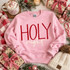 Holy Night DTF Transfer | Christmas Holiday Design, red and cream “Holy night” lettering displayed on a pink sweatshirt surrounded by Christmas gifts, greenery, ornaments, and a festive mug.