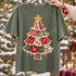 Whimsical patchwork Christmas tree DTF transfer with plaid, snowflake, holly, and heart fabric-print panels, crochet lace trim, gold star topper, and burlap trunk on a green shirt Shown on a Moss t-shirt.