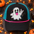 Rock On Ghost DTF transfer with colorful outline, pink tongue, and rock-on hand sign for Halloween shirts Shown on a black foam front panel, hot pink rope, teal mesh back trucker hat.