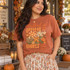 The Lord is Greater than the Giants You Face 1 John 4:4 DTF transfer with mixed-pattern wildflower bouquet in plaid, leopard, floral, and dotted motifs with green leaves and a butterfly Shown on a Terracotta t-shirt.