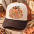 Cozy Season DTF Transfer | Gingham Plaid Fall Bubble Letter Design, orange gingham bubble lettering with autumn leaves and a tree stump displayed on a cream and rust trucker hat