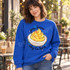 You Know Why I'm Here Deviled Egg DTF Transfer | Funny Potluck Design, colorful deviled egg illustration with playful lettering displayed on a blue sweatshirt worn by a woman