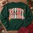 MIMI Christmas DTF transfer in block letters with candy cane stripes, holly berry, red checker, and leopard print patterns, accented with holly leaves, a jingle bell, and a candy cane, with mimi in red cursive script layered across the center Shown on a Fan Dark Green crewneck sweatshirt.
