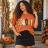 Spooky folk-art DTF transfer with patterned patchwork letters, a ghost replacing the O, a jack-o-lantern by the K, and flying bats above Shown on a Burnt Orange t-shirt.