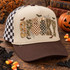 SPOOKY lettering DTF transfer with floral, camo, and leopard print fill, bow-topped checkered and polka-dot ghost characters, bats, and spiderwebs Shown on a khaki tan front panel, dark brown bill, black-and-white checkered mesh trucker hat.