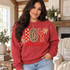 JOY faux-embroidered applique DTF transfer with red polka dot, leopard print, and cross-patterned letters, cream bows, and red script John 16:22 Bible verse Shown on a Heather Scarlet Red crewneck sweatshirt.