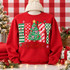 Merry Christmas DTF transfer with patterned block letters, a decorated Christmas tree with gold star and pink bows, and red script Christmas lettering Shown on a Red crewneck sweatshirt.