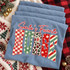 Santa's Favorite Nurse Christmas DTF transfer with script lettering and block letters in buffalo check, polka dot, leopard print, star, and candy stripe patterns Shown on a Chambray t-shirt.