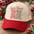 Santa's Favorite RN Christmas DTF transfer with red script lettering, checkerboard R with striped star, and candy-cane striped N Shown on a cream front panel, red bill, cream mesh back trucker hat.