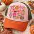 God Is Faithful In Every Season DTF transfer with polka-dot and floral pumpkins, plaid bows, and floral crosses in a colorful hand-lettered fall faith design Shown on a blush pink front panel, burnt orange bill, olive mesh back with cream rope trucker hat.
