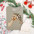 Whimsical polka-dot ostrich DTF transfer wearing a buffalo check Santa hat tangled in Christmas lights
