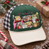 Pop-art Christmas movie mashup DTF transfer with polaroid-style frames featuring classic holiday movie characters, a leg lamp, BB gun, squirrel, and FRIENDS-style lettering Shown on a forest green front panel with cream bill and black-and-white buffalo check mesh back trucker hat.