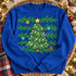 Hand-illustrated Christmas tree DTF transfer with glowing string lights, colorful ornaments, a gold star topper, pine branches, and scattered gold, teal, and red stars Shown on a Royal crewneck sweatshirt.