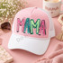 Playful graffiti-style MAMA DTF transfer in alternating pink, teal, and green hand-lettered letters with black outlines and white highlights Shown on a blush pink front panel with white pre-curved bill and white mesh back trucker hat.